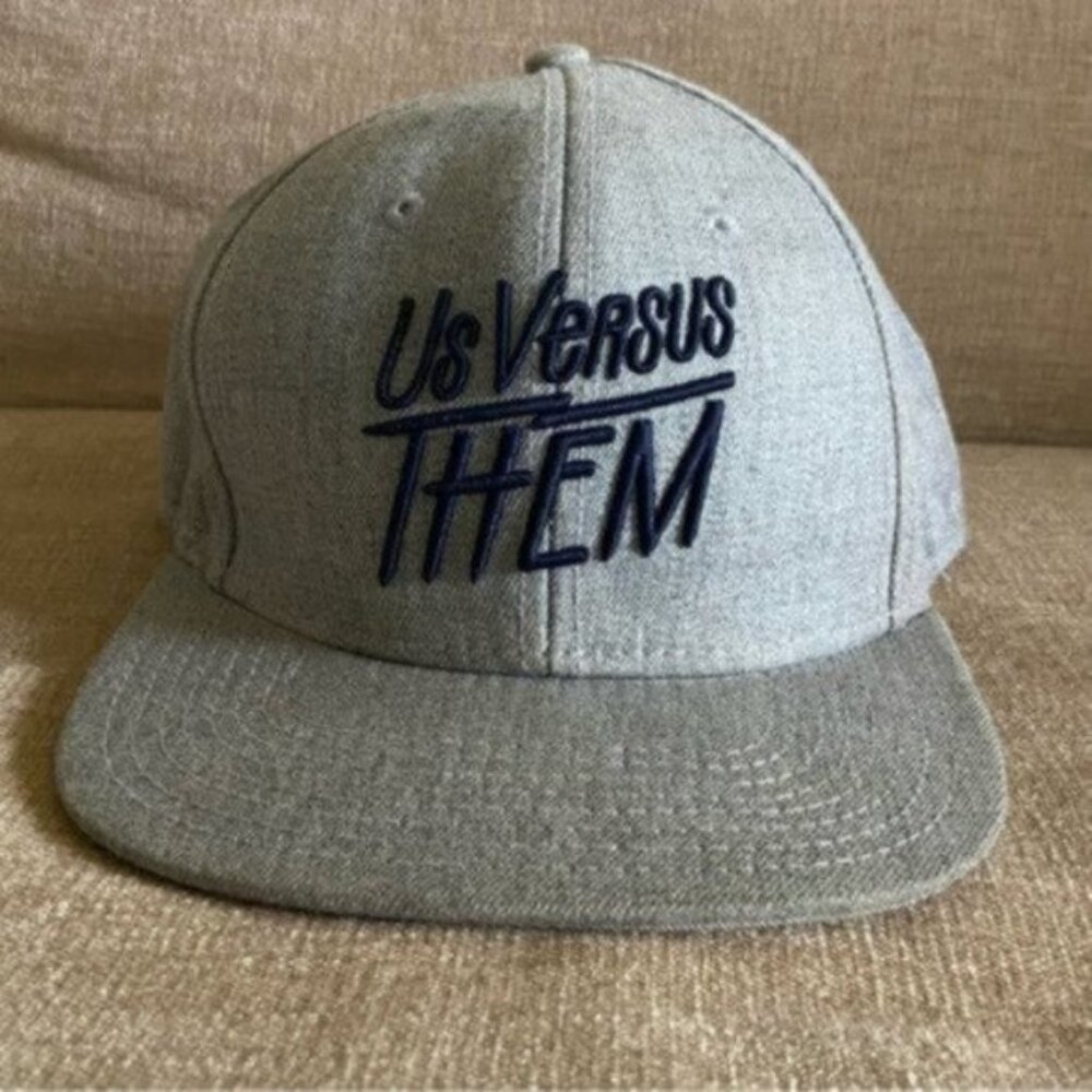 Us Versus Them Adjustable Snapback Cap.